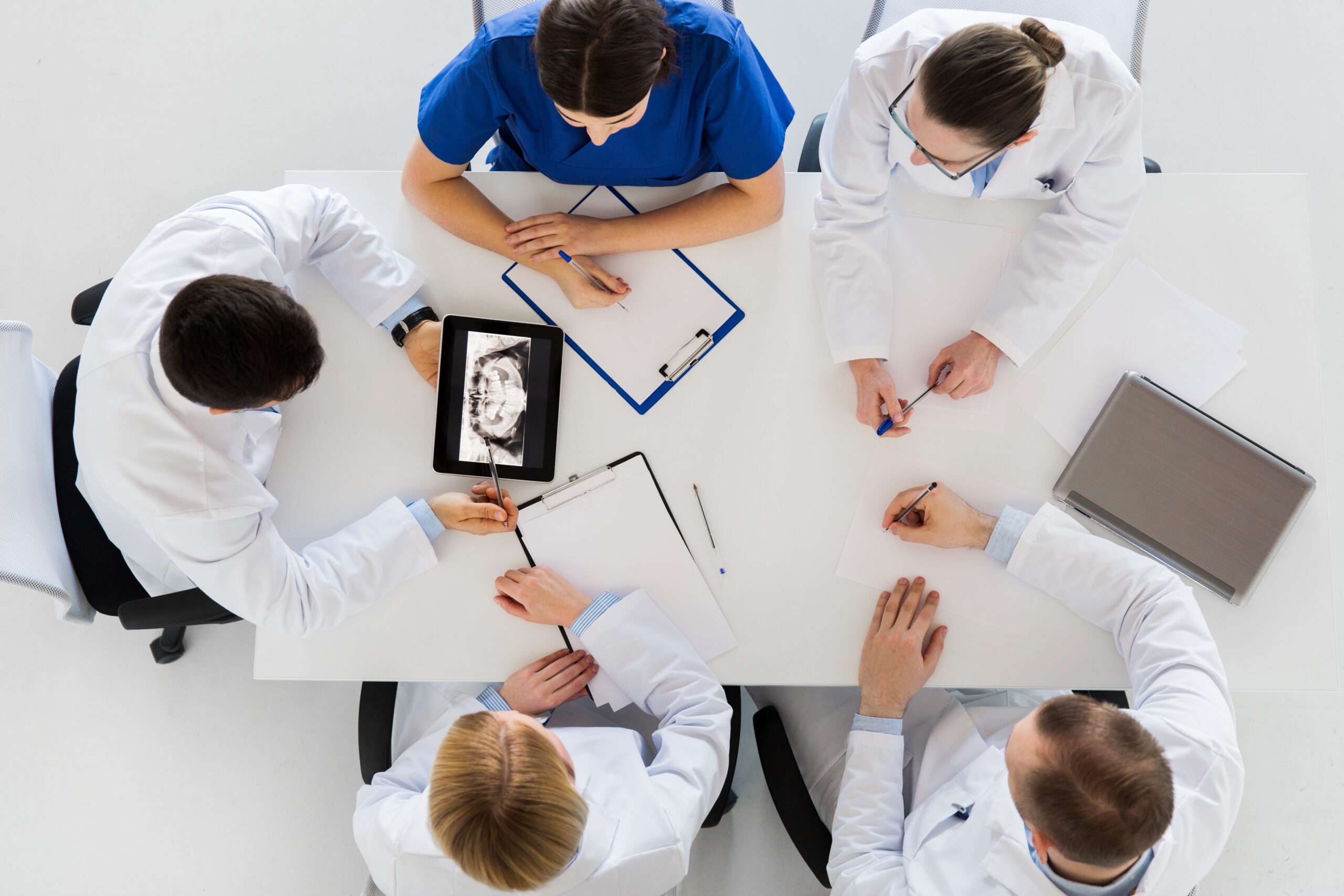 birds eye view of dentists meeting and reviewing charts